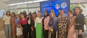 Grupo de mulheres posando para foto em frente a uma tela, onde se lê o nome do evento "Café com Administradores".